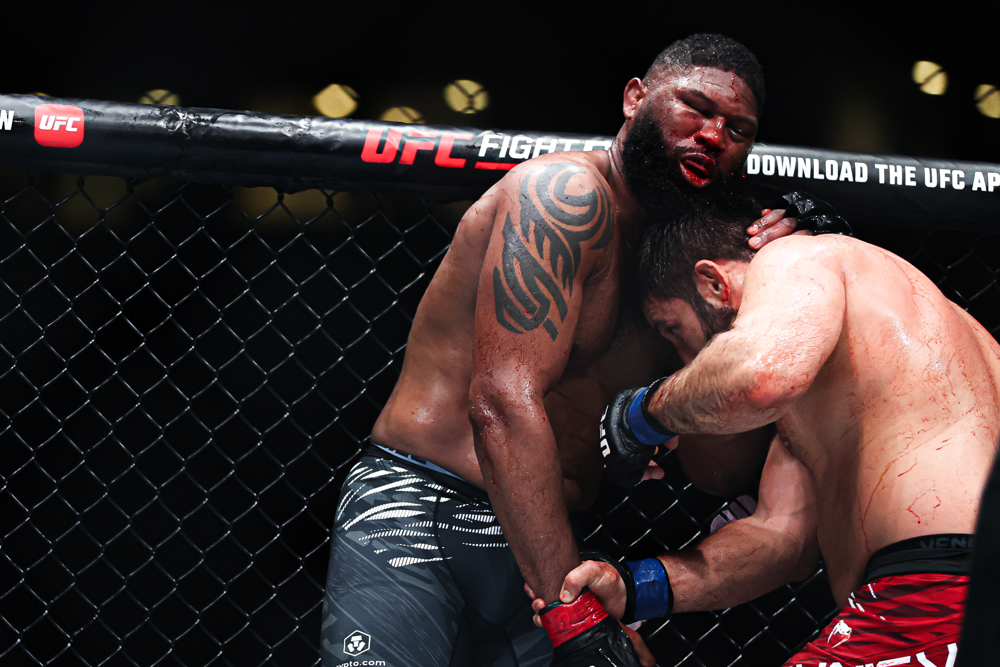 Curtis Blaydes (left) battles Rizvan Kuniev in a grueling clinch exchange. Blaydes’ nose is bloodied as the UFC newcomer Kuniev pushes him to the limit in their split-decision fight